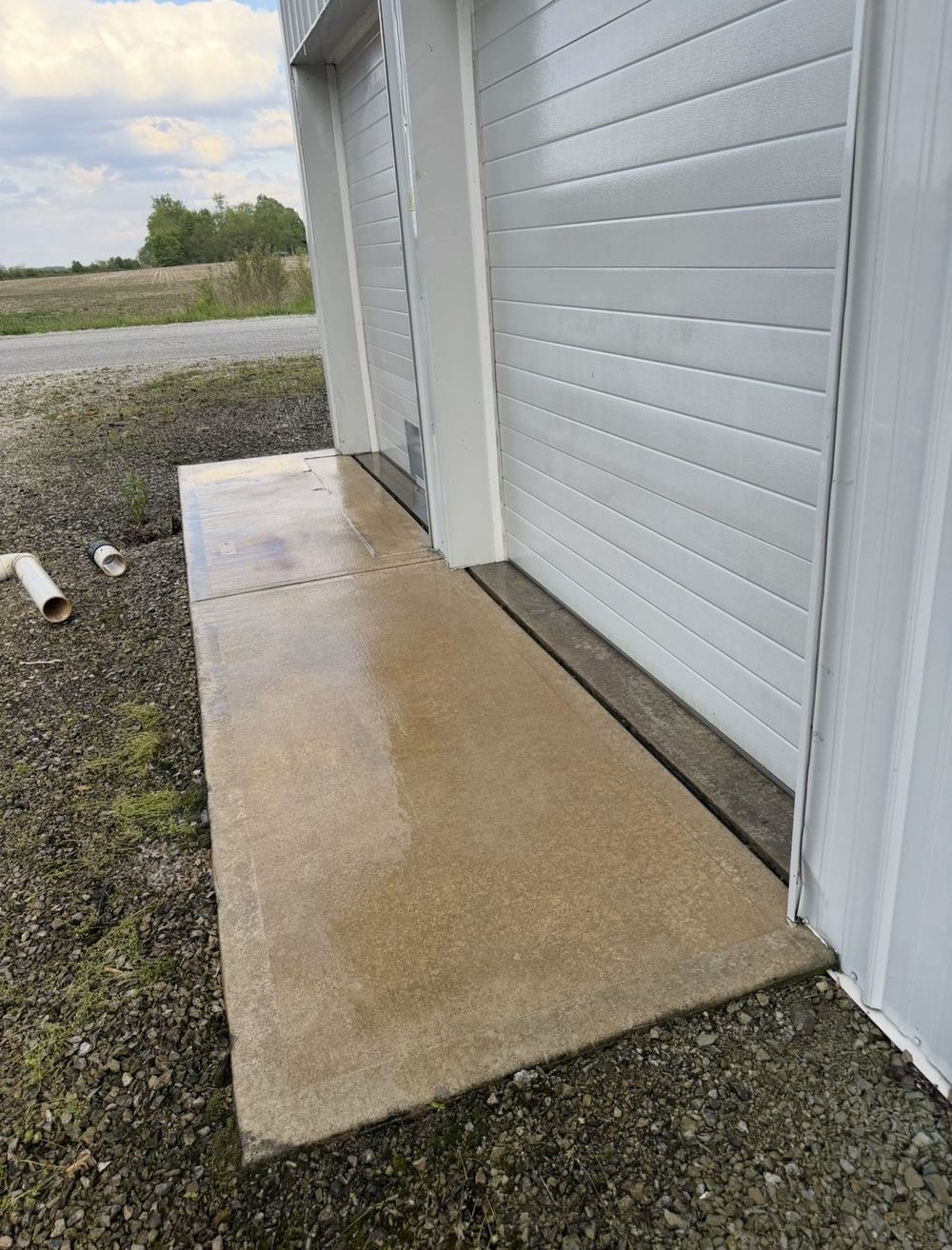 The same concrete walkway after pressure washing, original light color restored